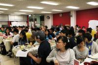 Students listening intently at speakers during communal dinner
